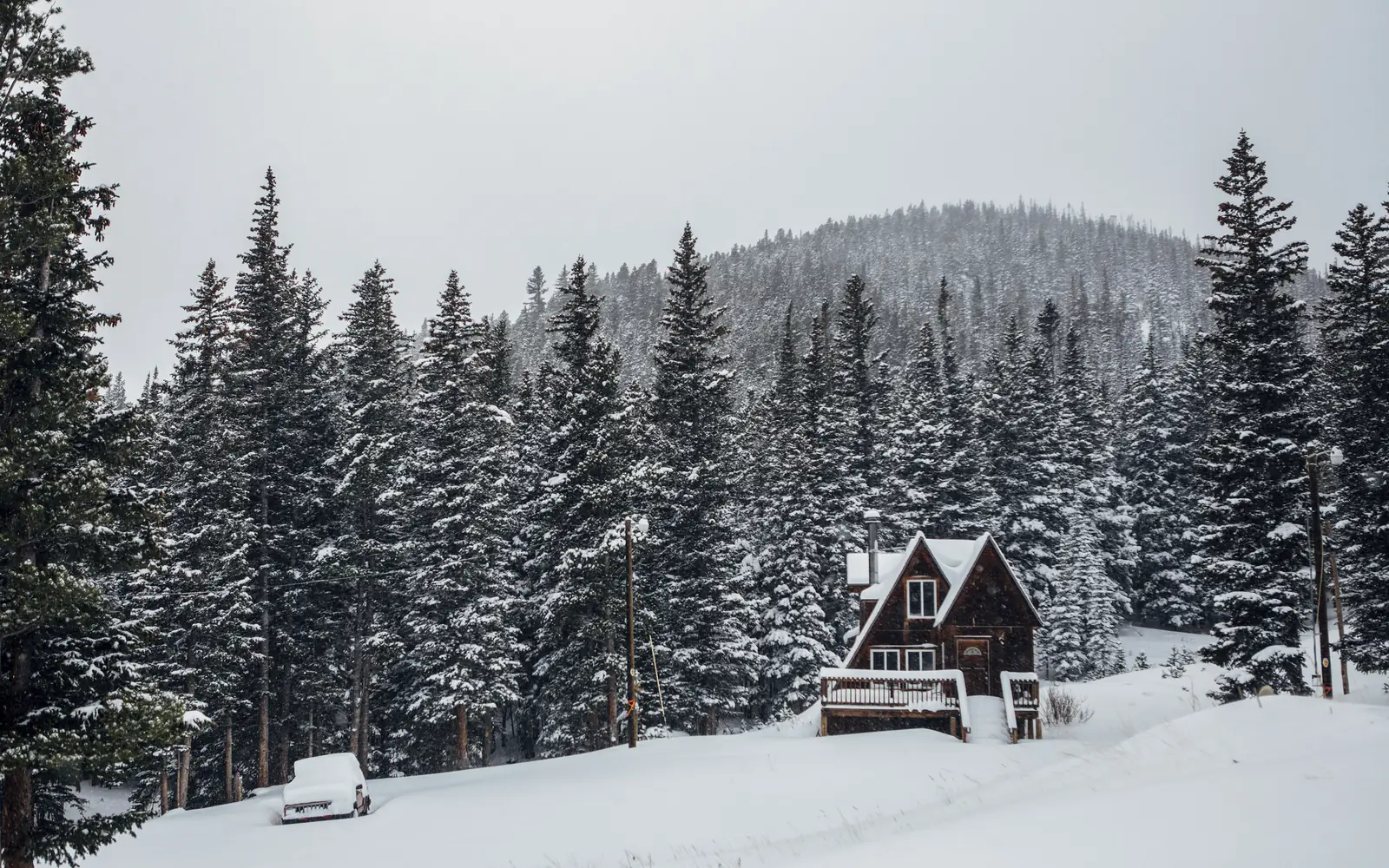 A-frame house in a snowy spruce valley in the Colorado mountains