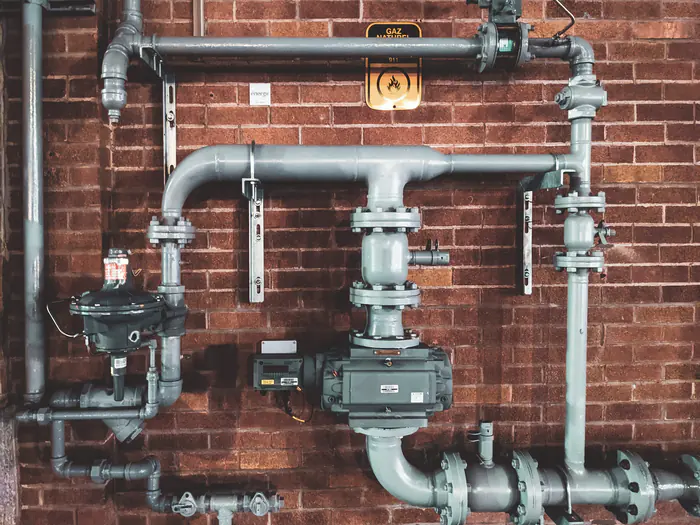 Gas meter and piping on a brick wall